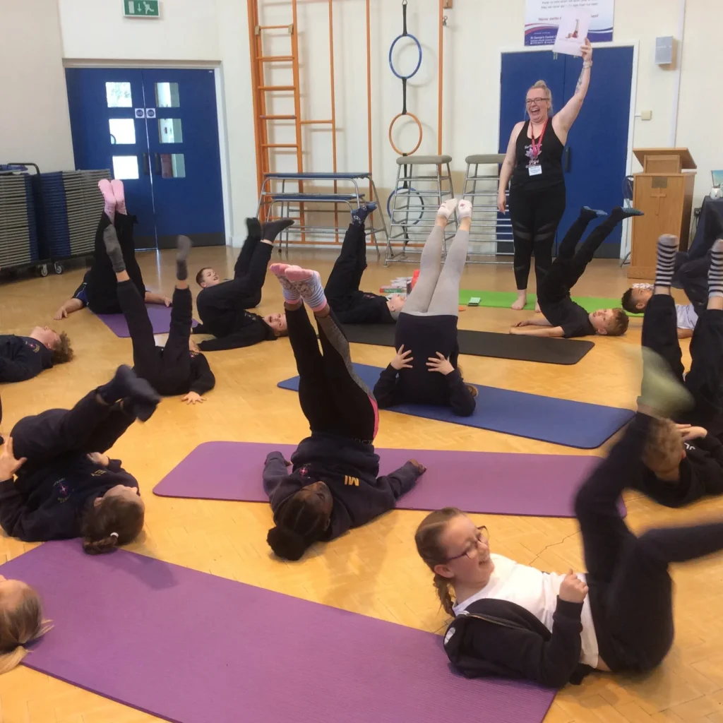 Primary school pupils practising mindful movement and balance activities during a yoga session in Bolton